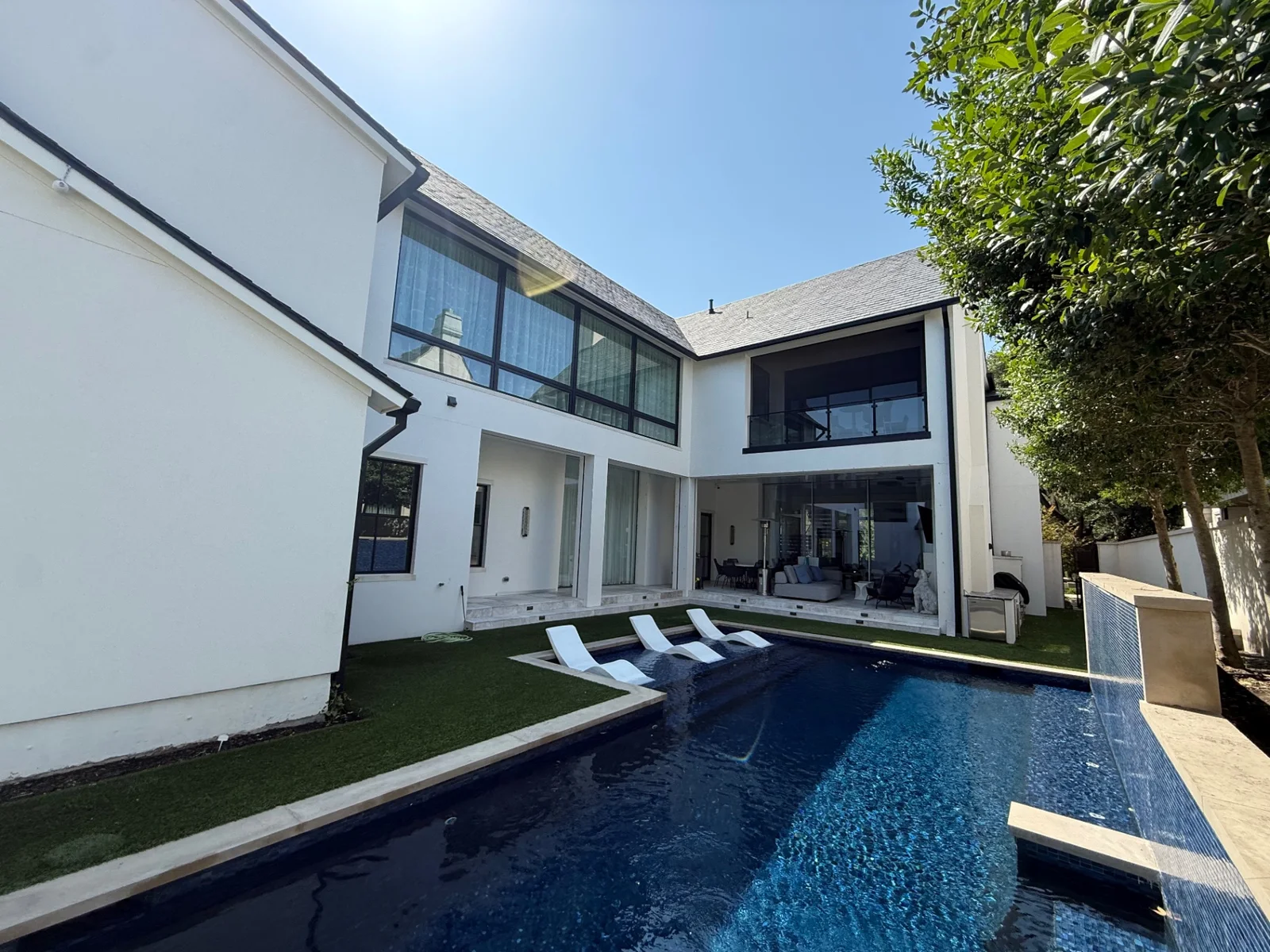 Clean floor-to-ceiling windows overlooking a modern pool at a Dallas luxury home