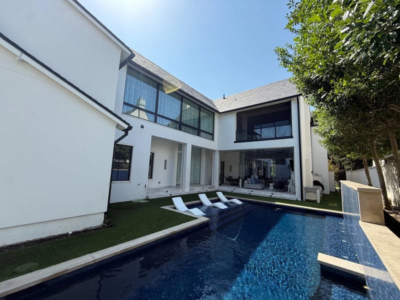 Clean floor-to-ceiling windows overlooking a modern pool at a Dallas luxury home