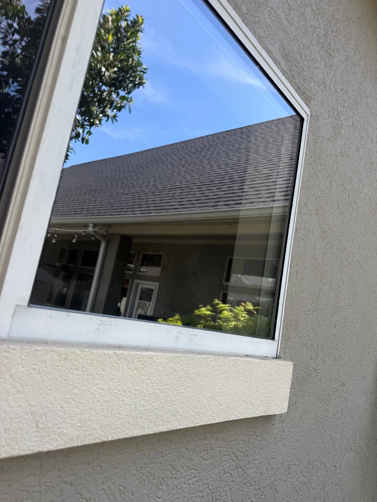 Close-up of streak-free residential window glass reflecting blue sky after professional cleaning