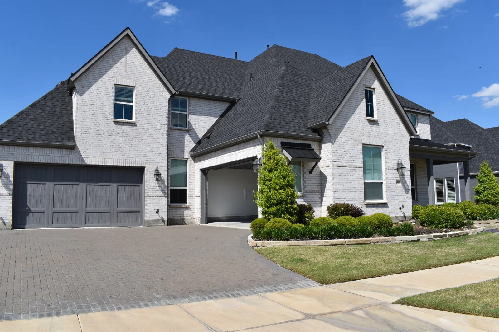 Professional window cleaning at a manicured white-brick luxury home in North Dallas, TX