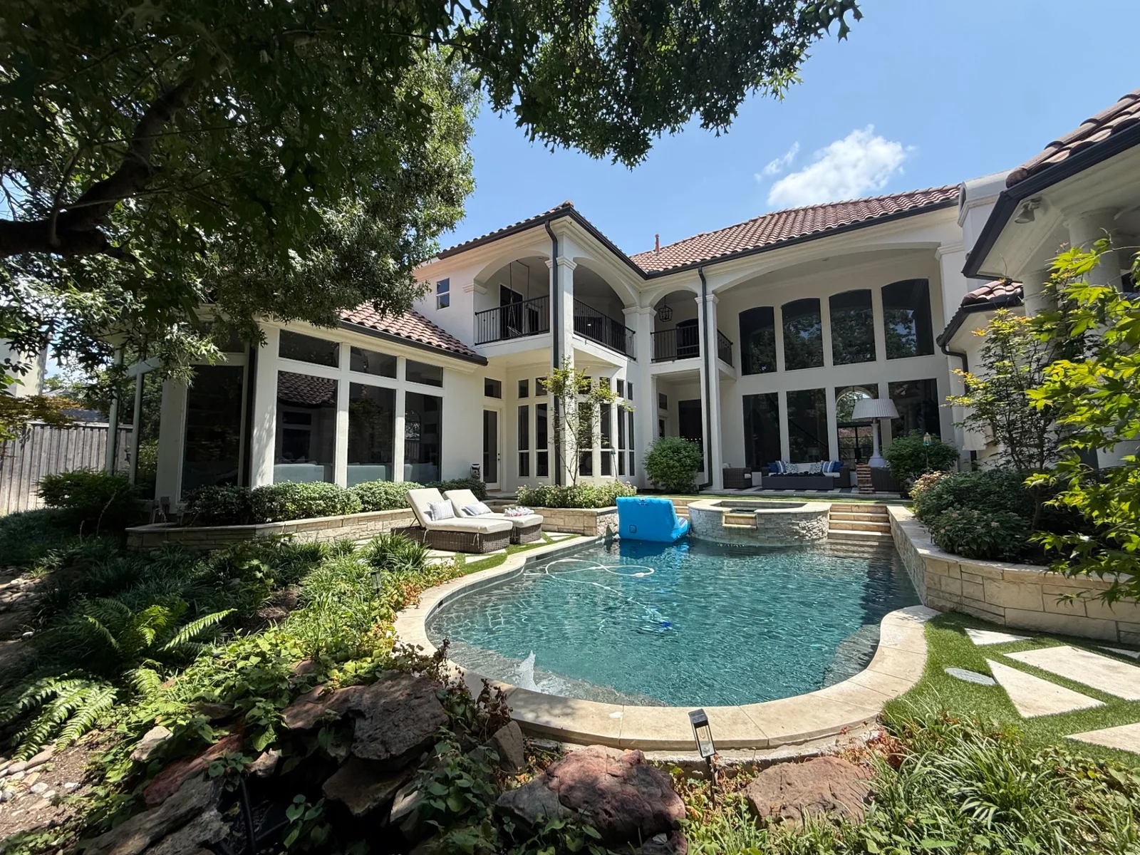 Professional window cleaning across a landscaped luxury poolside residence in North Dallas