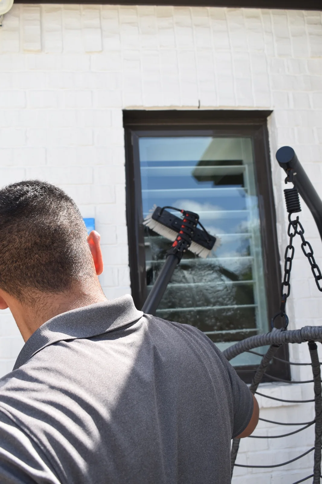 Professional exterior window cleaning with a water-fed brush at a luxury North Dallas residence
