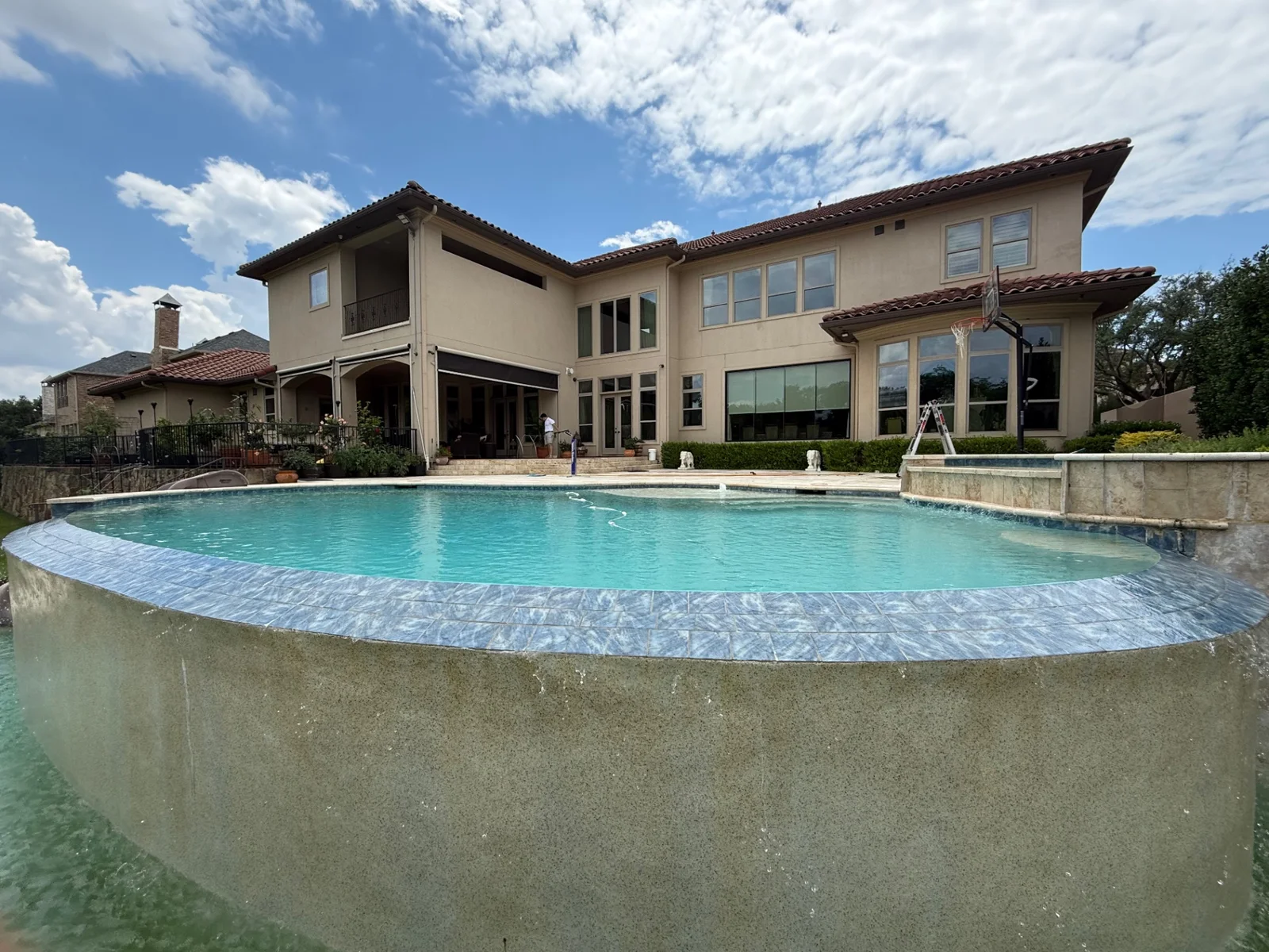 Professional window cleaning at a multi-story poolside estate in the Dallas-Fort Worth area