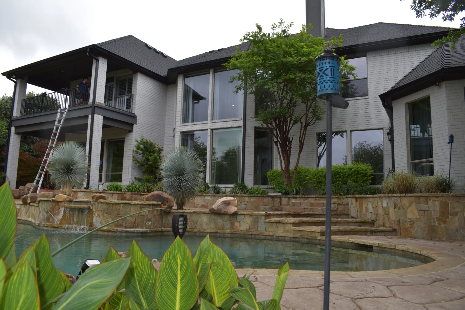 Professional window cleaning across a two-story poolside estate in the Dallas-Fort Worth area