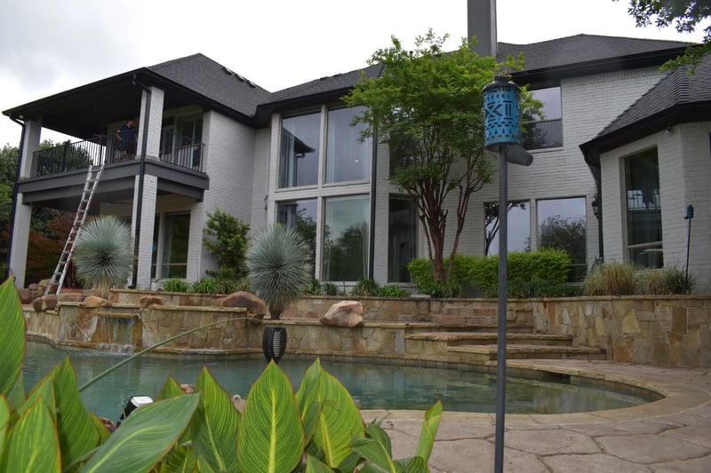 Professional window cleaning across a two-story poolside estate in the Dallas-Fort Worth area