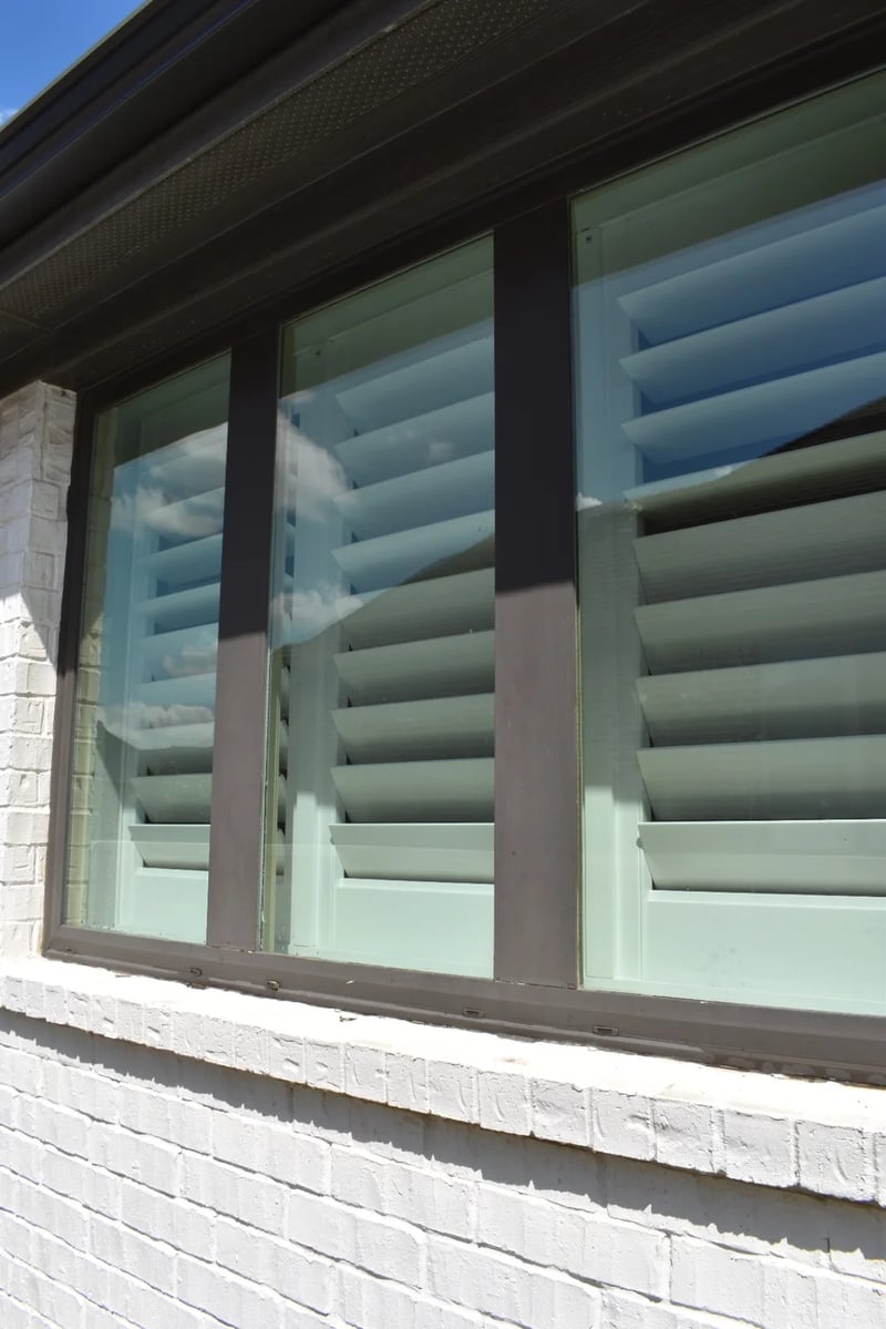 Freshly cleaned residential windows with clear reflections on a white brick home in Dallas-Fort Worth