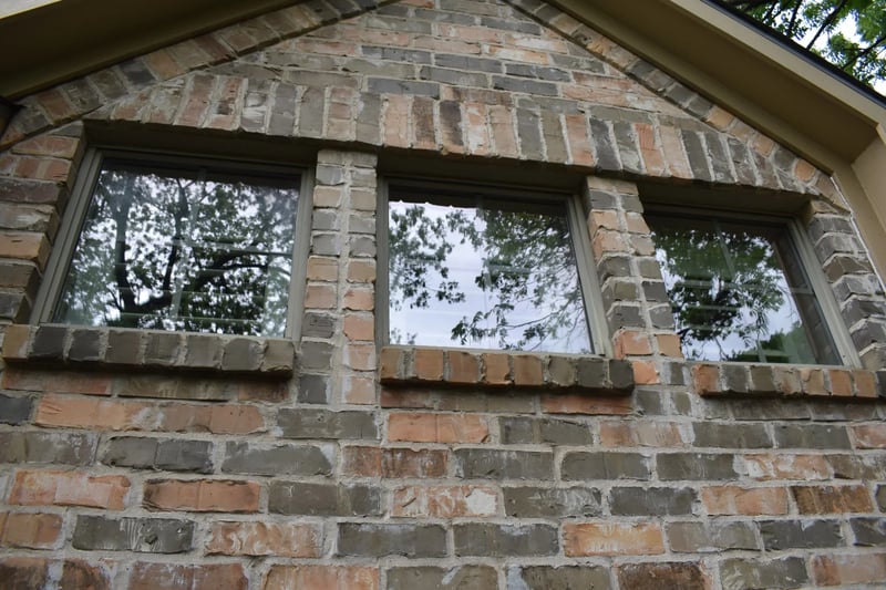 Clean upper-story windows with clear reflections on a brick home in North Dallas, TX