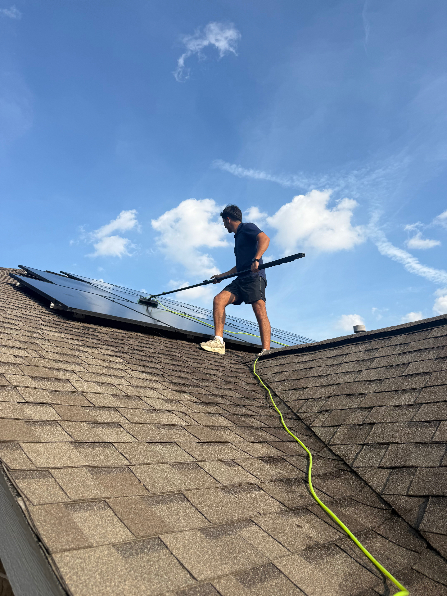 Professional solar panel cleaning on a residential rooftop