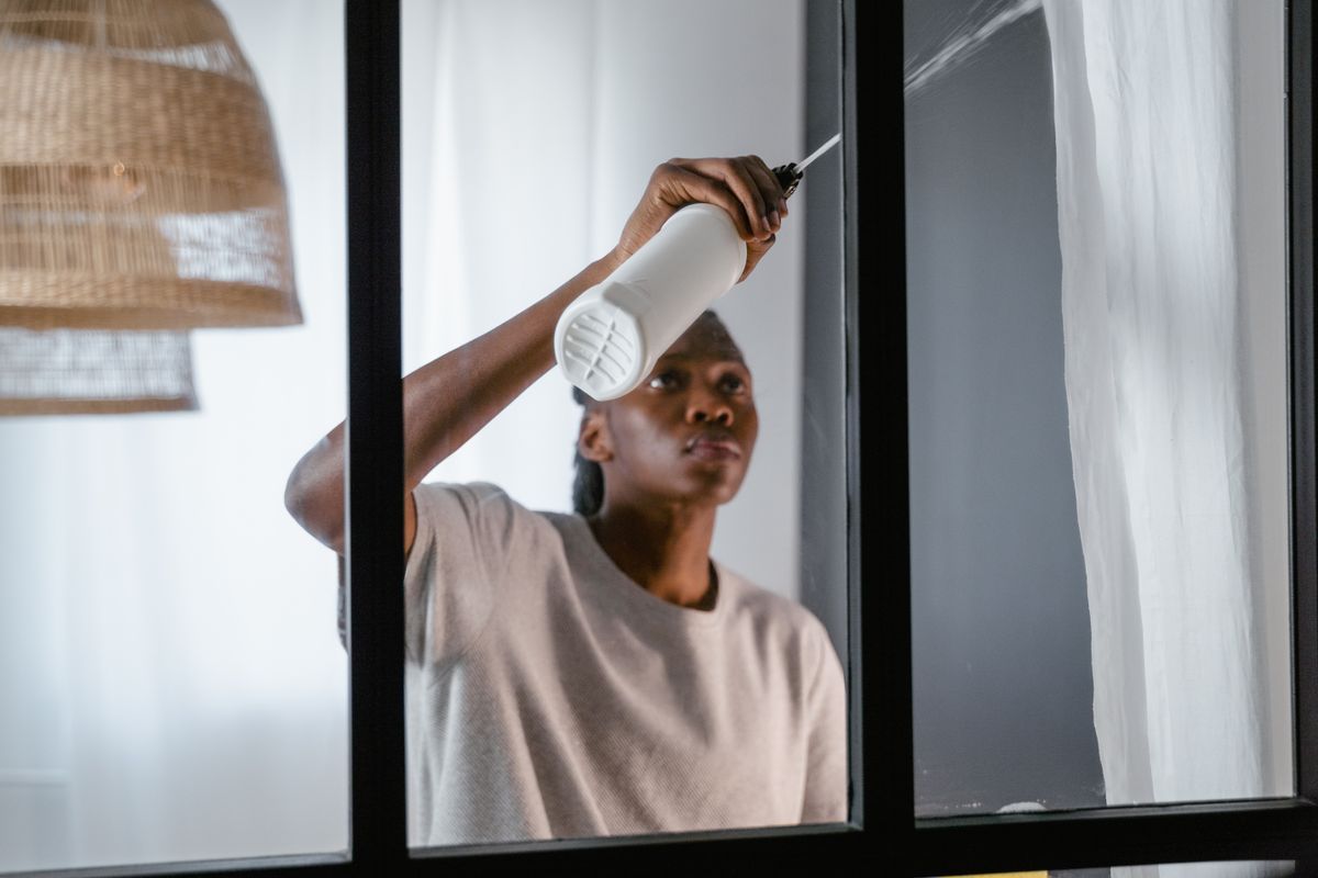 Cleaning a window frame and sill by hand indoors