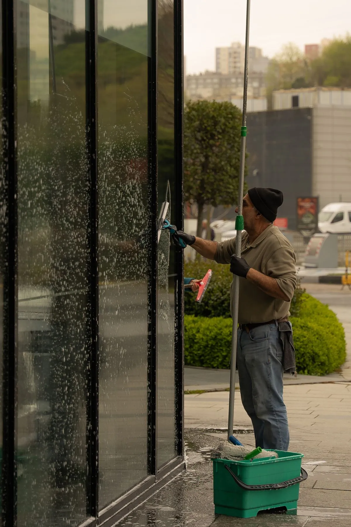 Professional window cleaner squeegeeing exterior glass